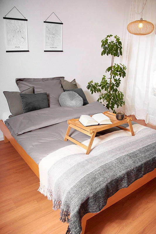Decke aus brauner und weißer Alpakawolle auf einem Bett in einem Schlafzimmer.  Dieses Bild ist ein Link, der zur Home-Produktseite führt.