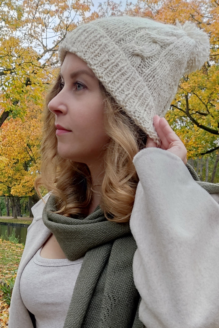 Blondes Model mit einer handgemachten Alpakamütze in weißer Farbe