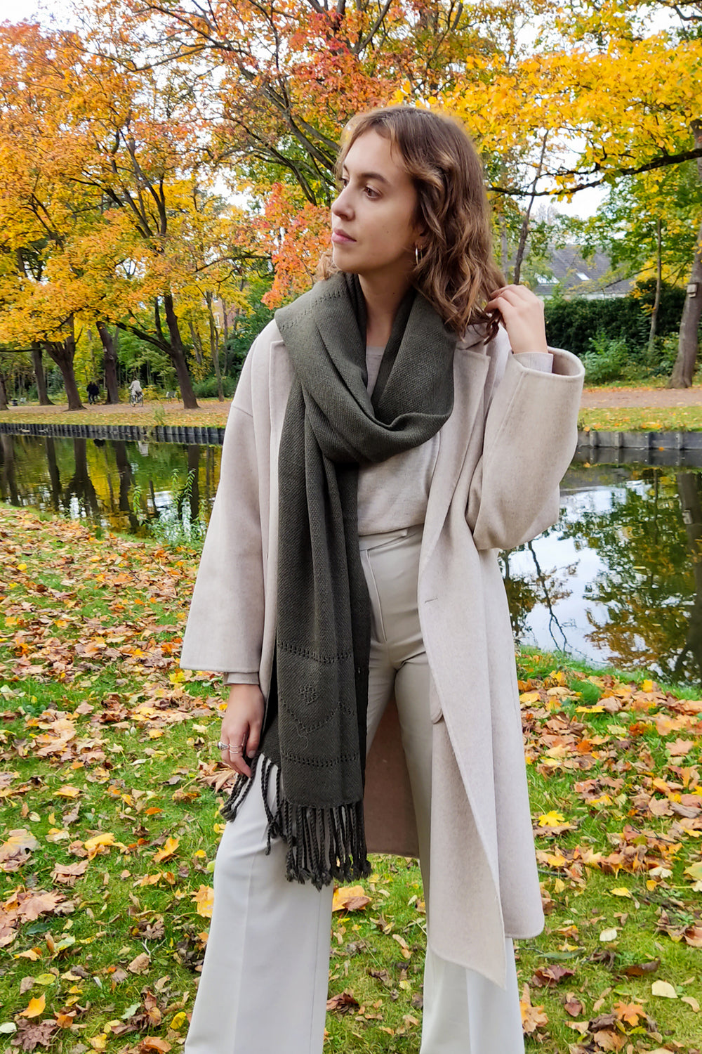 Model mit einem grünen Schal aus Alpakawolle mit Lochmuster
