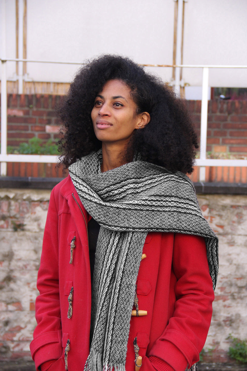 Ein Model mit einem Schal aus weißer und schwarzer Alpaka Wolle mit Tribal-Muster