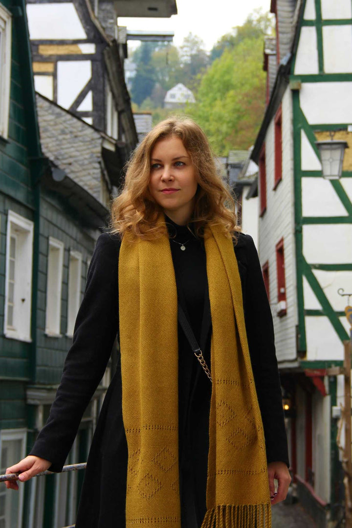 Ein Model mit einem Gelben Alpaka Wolle Schal mit Lochmuster