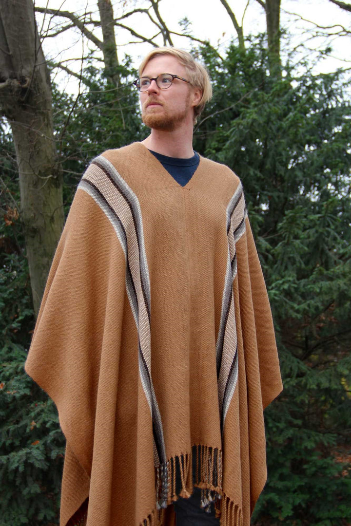 Blondes Model mit dem handgemachten Llaima Alpaka-Poncho in brauner Farbe mit Tribal-Motiven.