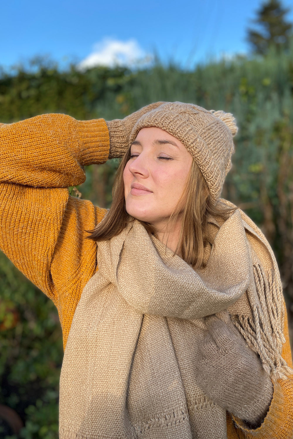 Model mit einem braunen Schal aus Alpakawolle mit Lochmuster