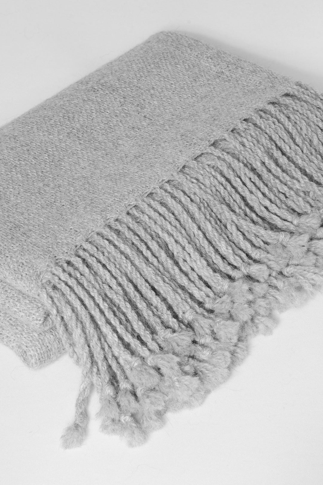 Gefalteter hellgrauer Alpaka-Poncho