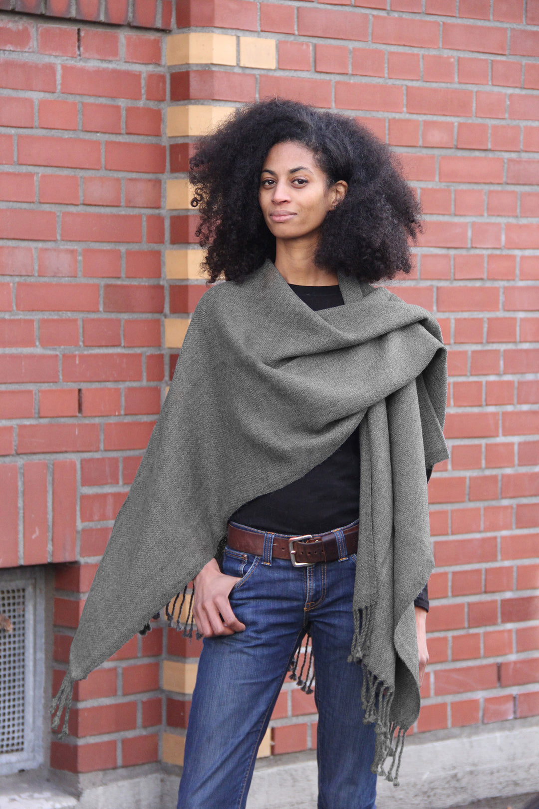 Afrikanisches Model mit dem Tupungatito Alpaka-Umhang in Dunkelgrau.