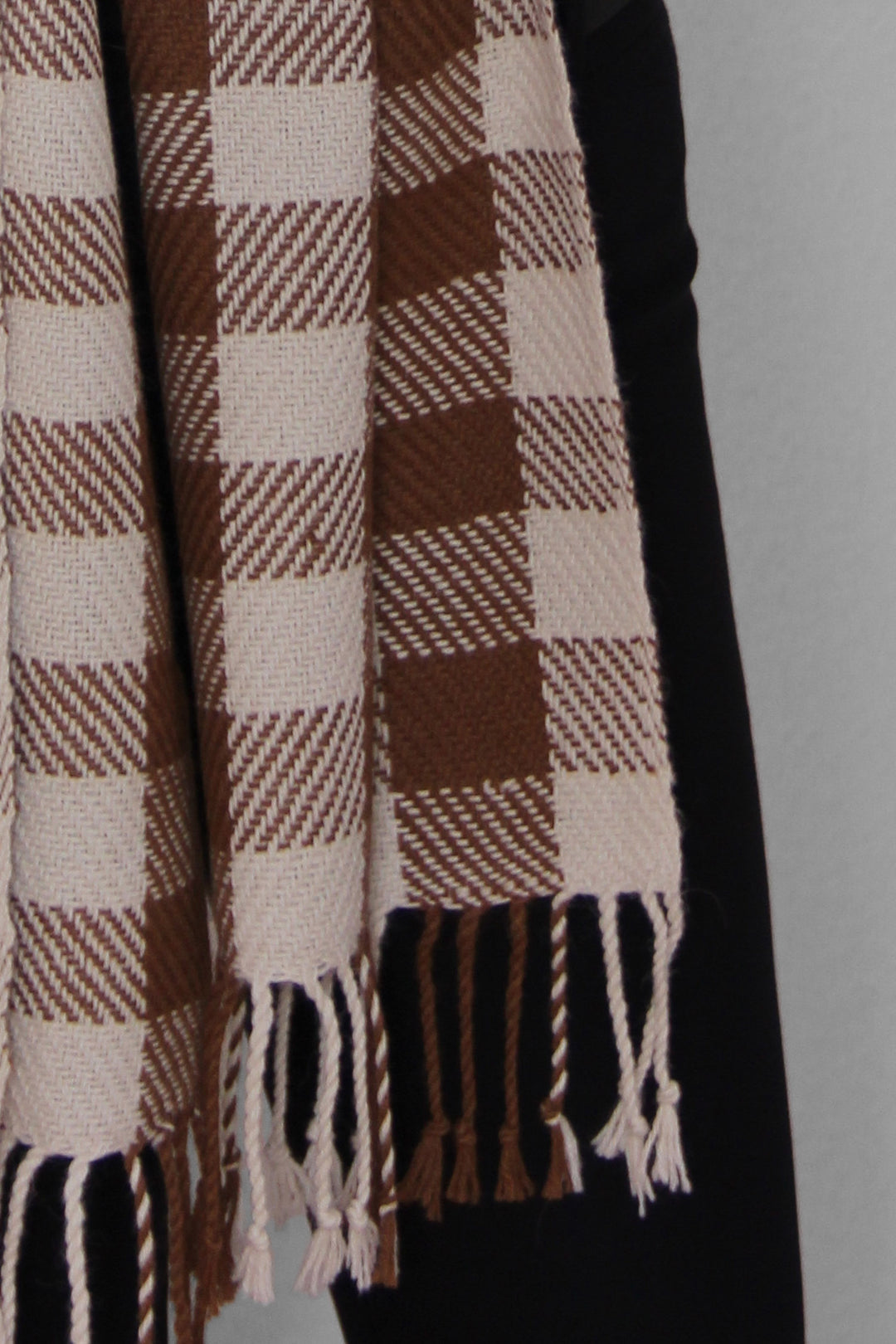 Karierter Schal aus Alpakawolle in braunen und weißen Farben mit Fransen.