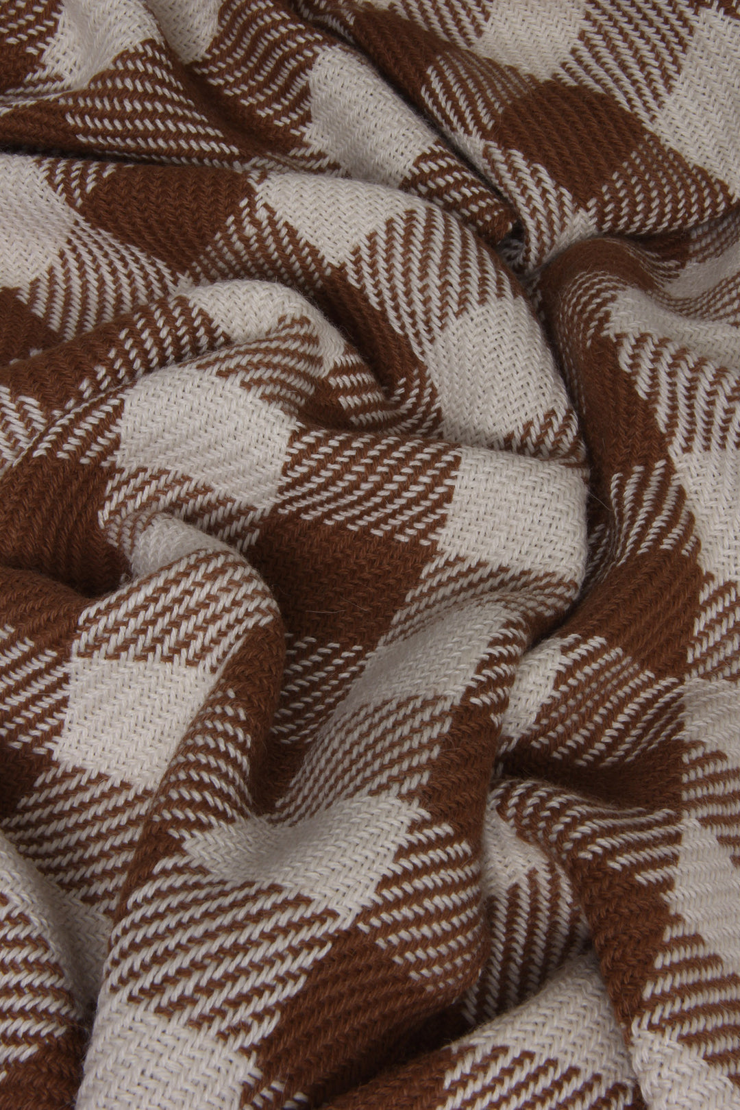 Karierter Schal aus Alpakawolle in braunen und weißen Farben. Muster in Nahaufnahme