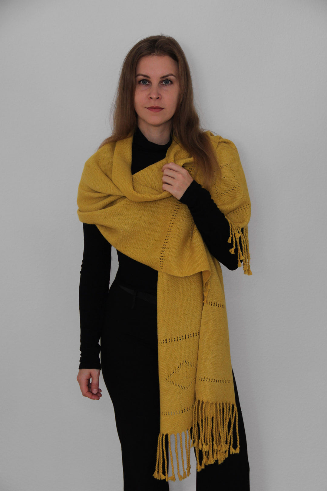 Model mit einem gelben Schal aus Alpakawolle mit Lochmuster
